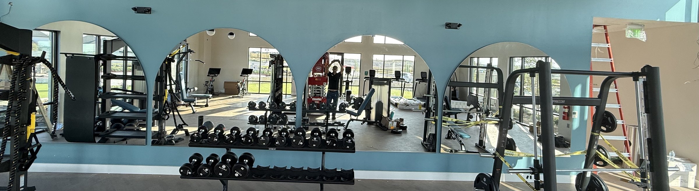 Custom arched mirror wall installed by Master Glass Solutions in a fitness center