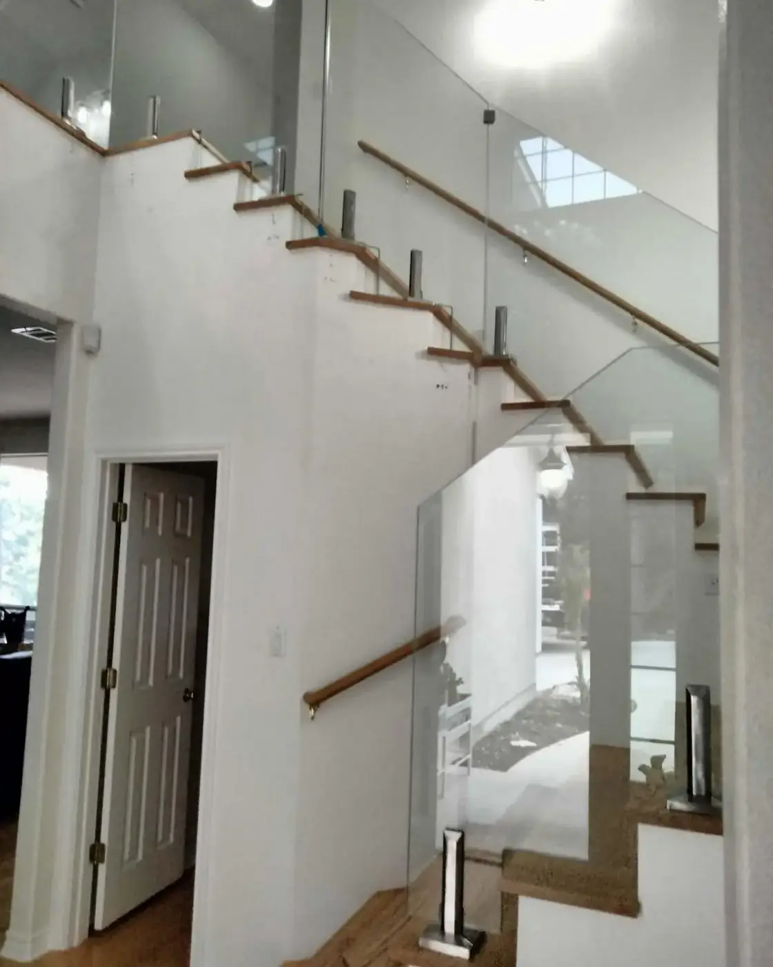 Glass stair railing with wood handrail